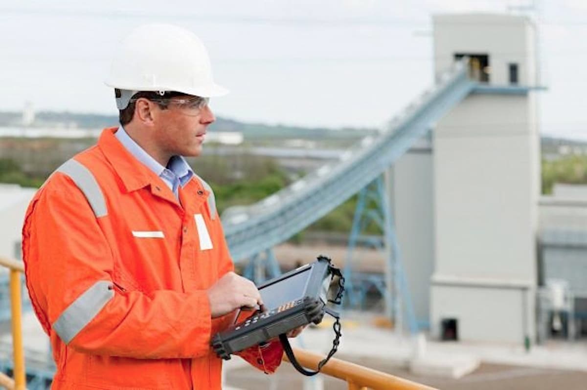 SAP user in hard hat overlooking factory