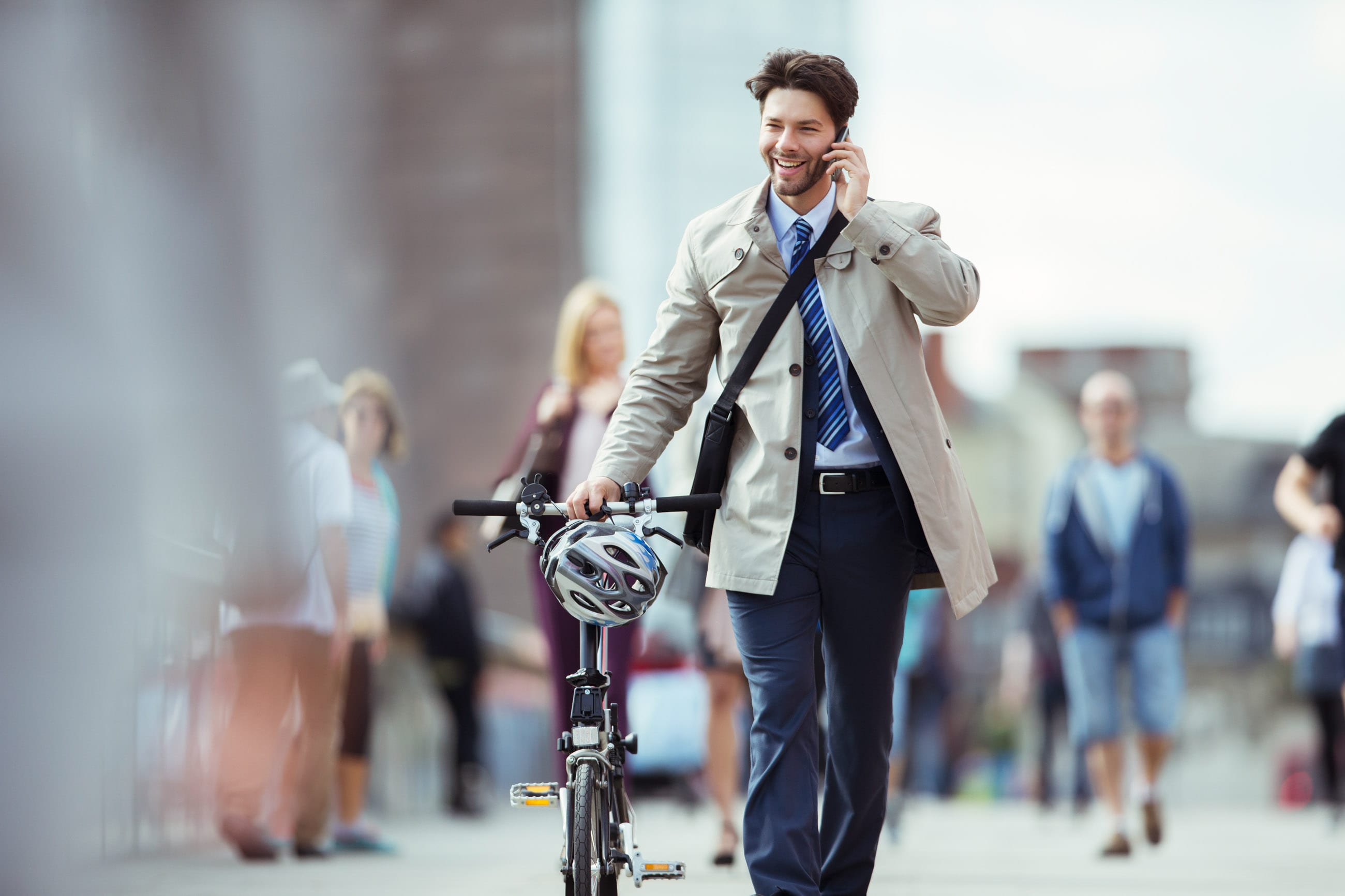 Man walking with bike while on phone