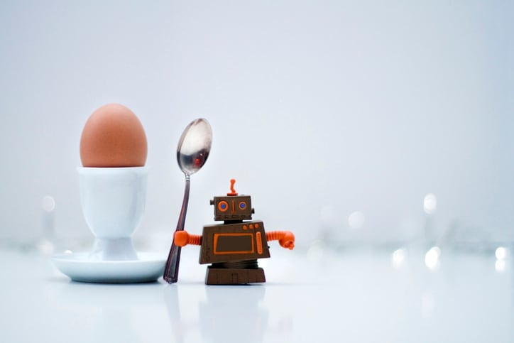 Robot holding a spoon next to an egg in an egg cup