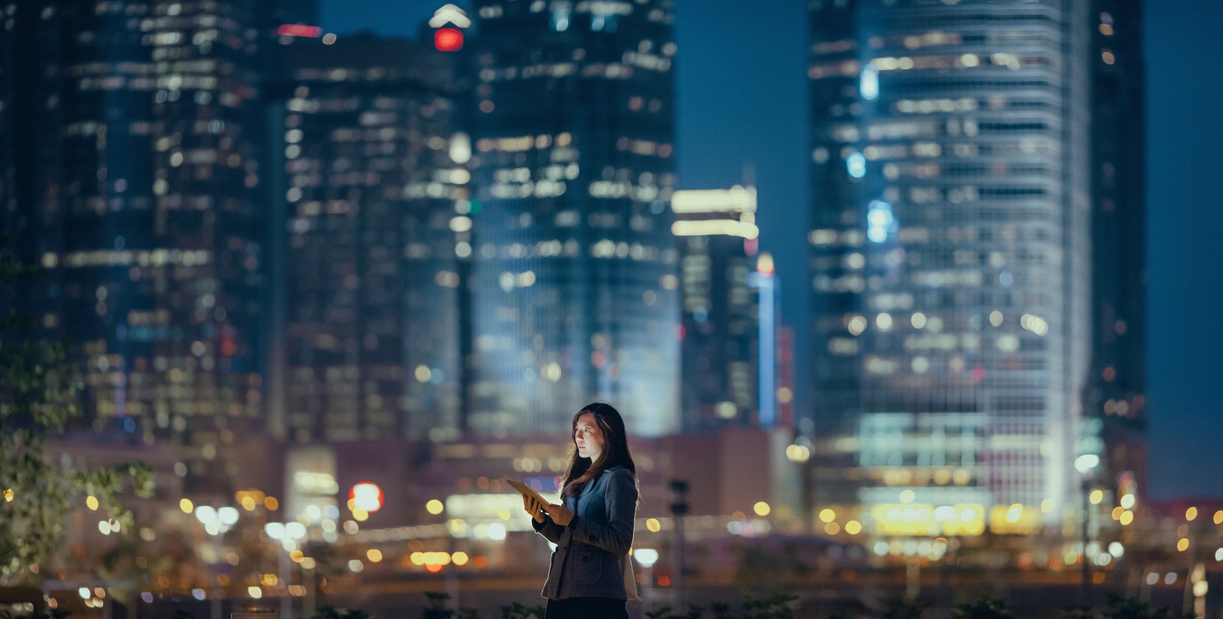 Woman in front of cityscape at night