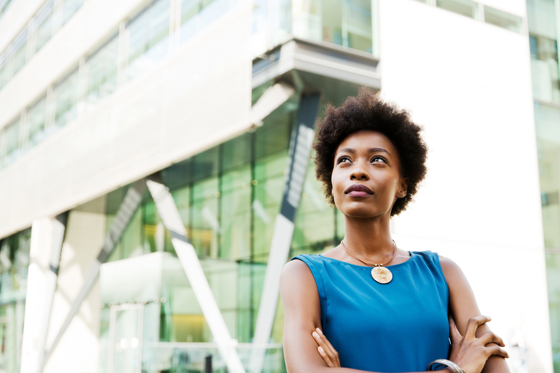 Woman standing in city-scape, arms crossed