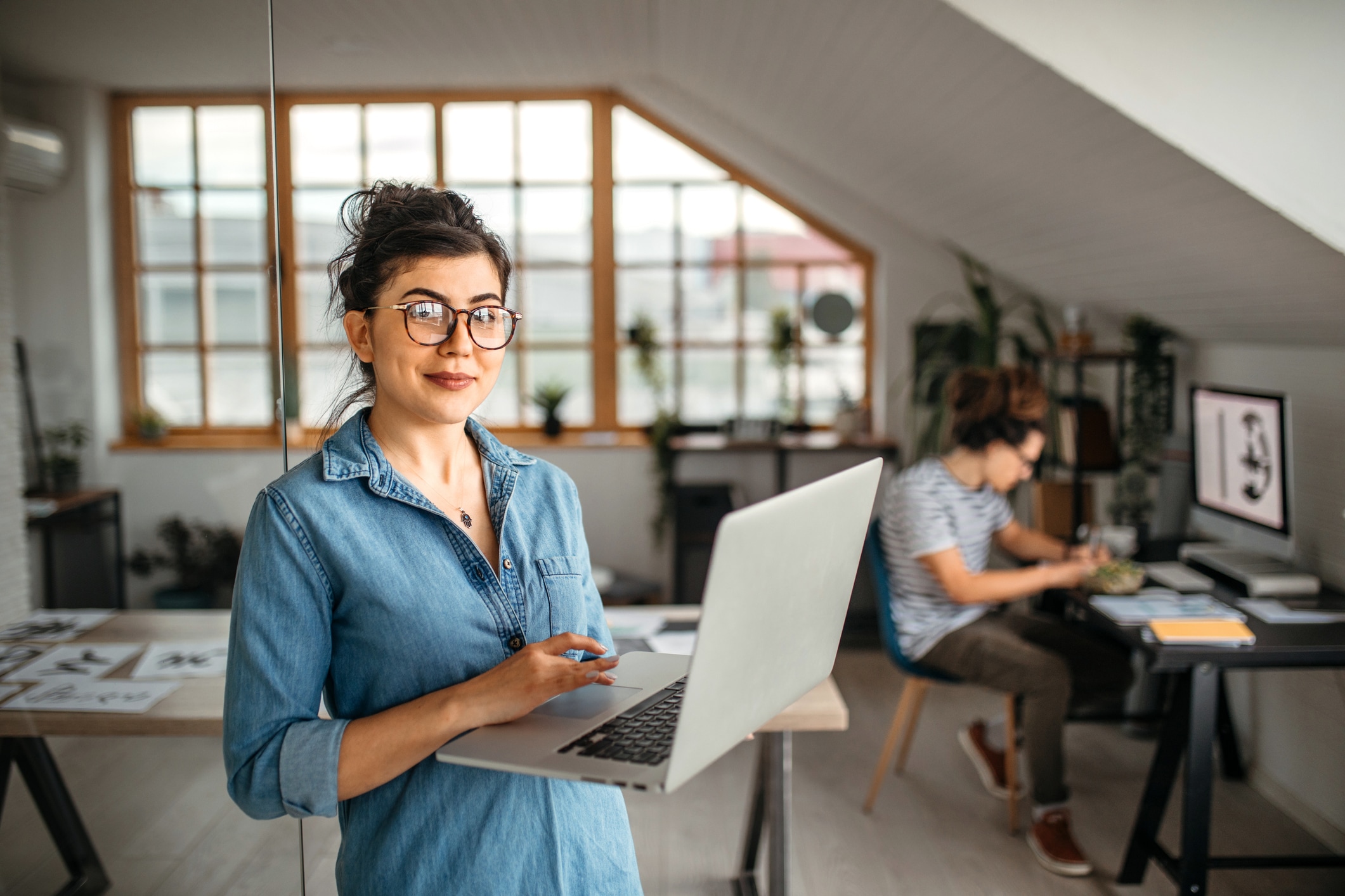 Woman in eyeglasses holding laptop