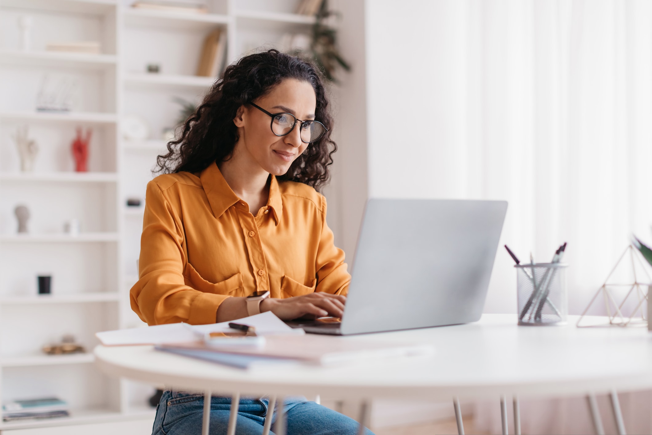 Woman wearing glasses working on laptop