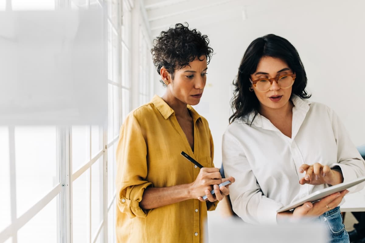 Women working on tablet and notepad