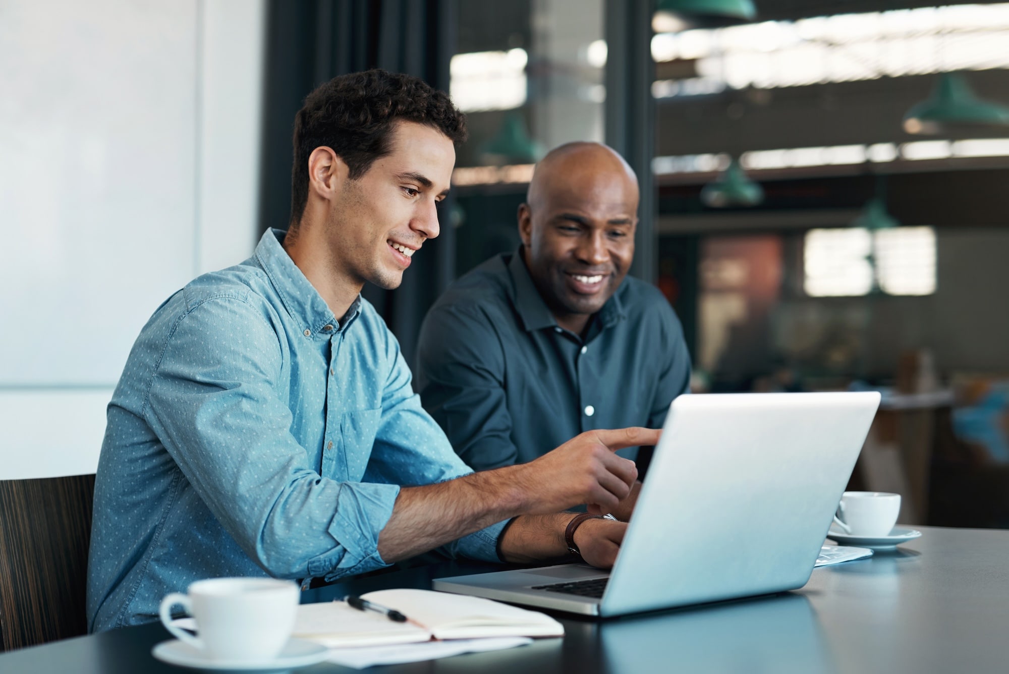 Two men working on a laptop