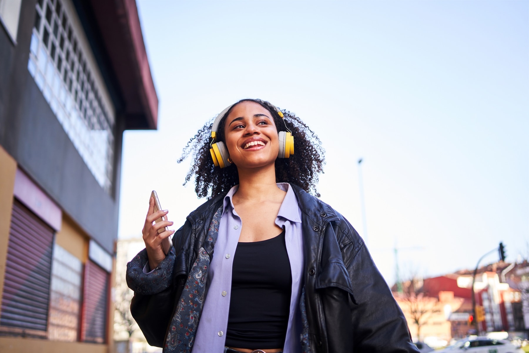 Traveller walking through city wearing headphones