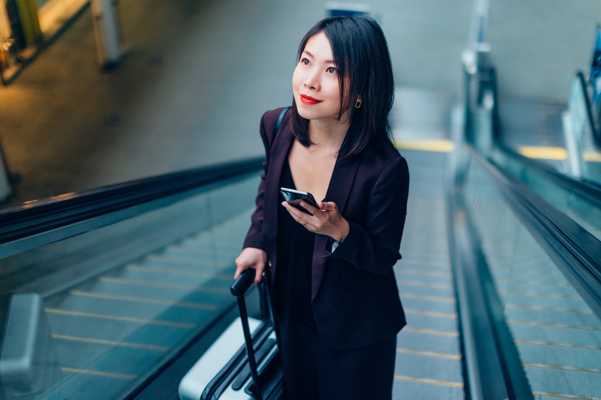 Woman with suitcase holding phone