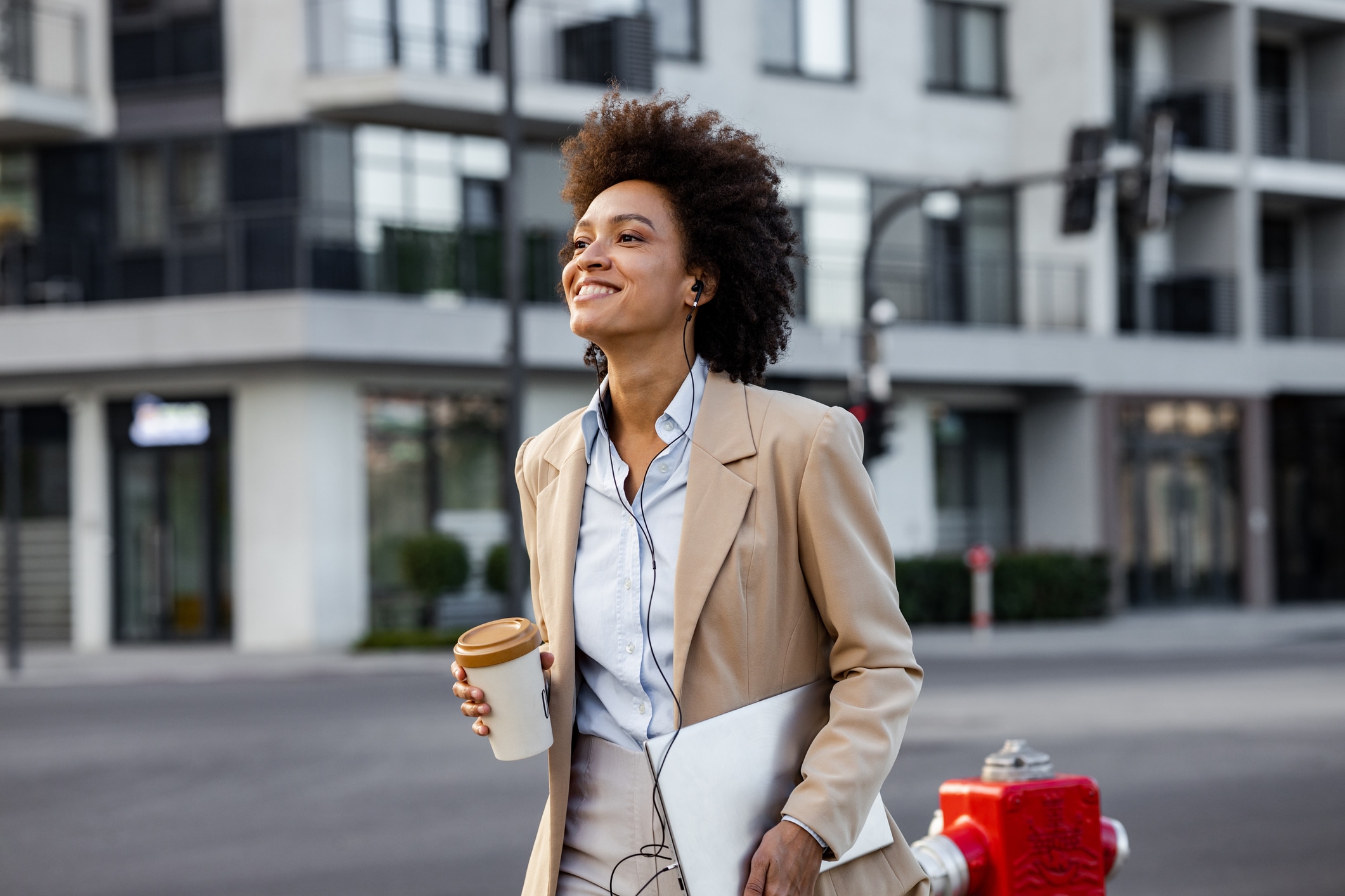 Woman with earbuds holding coffee