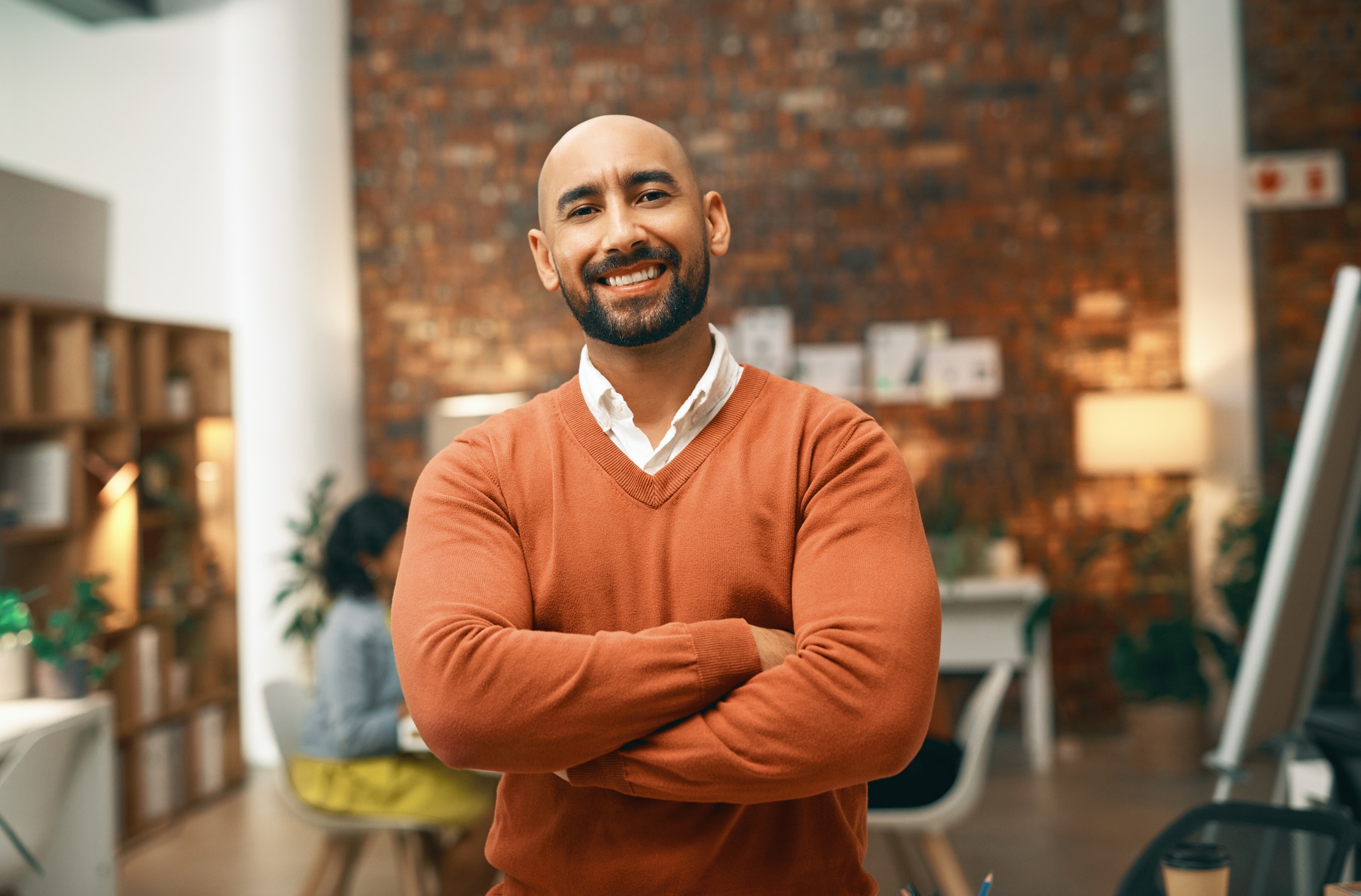 Man crosses arms and smiles at camera