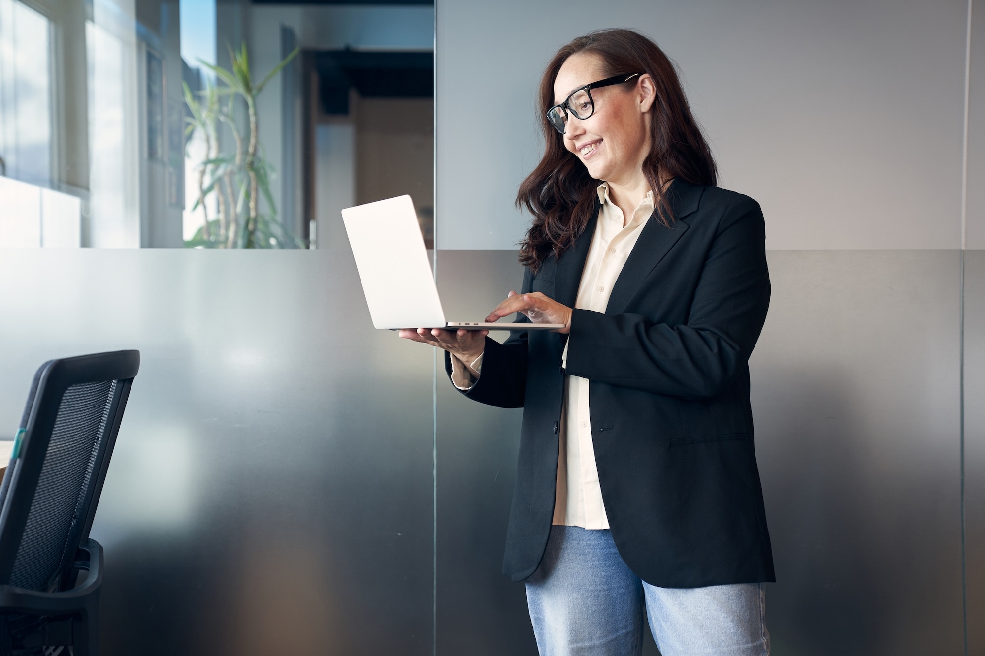 Woman wearing glasses working on laptop