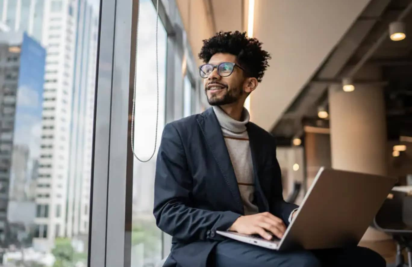 Man wearing glasses working on laptop