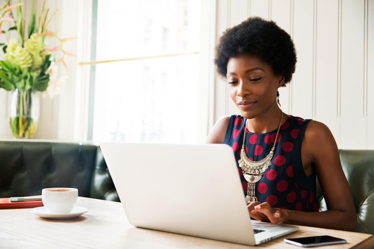 Female CFO and SAP Concur user working on laptop in a cafe